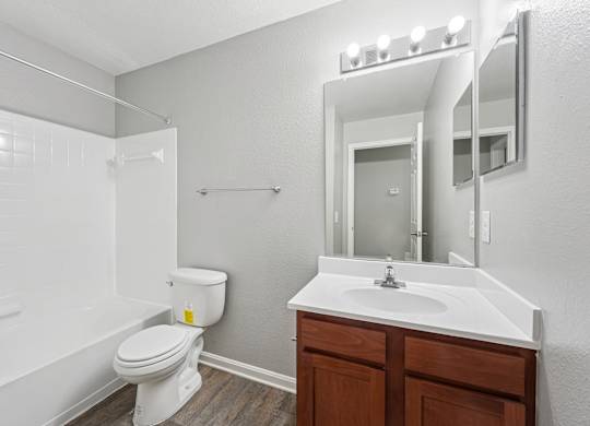 A white toilet sits next to a white sink in a small bathroom.